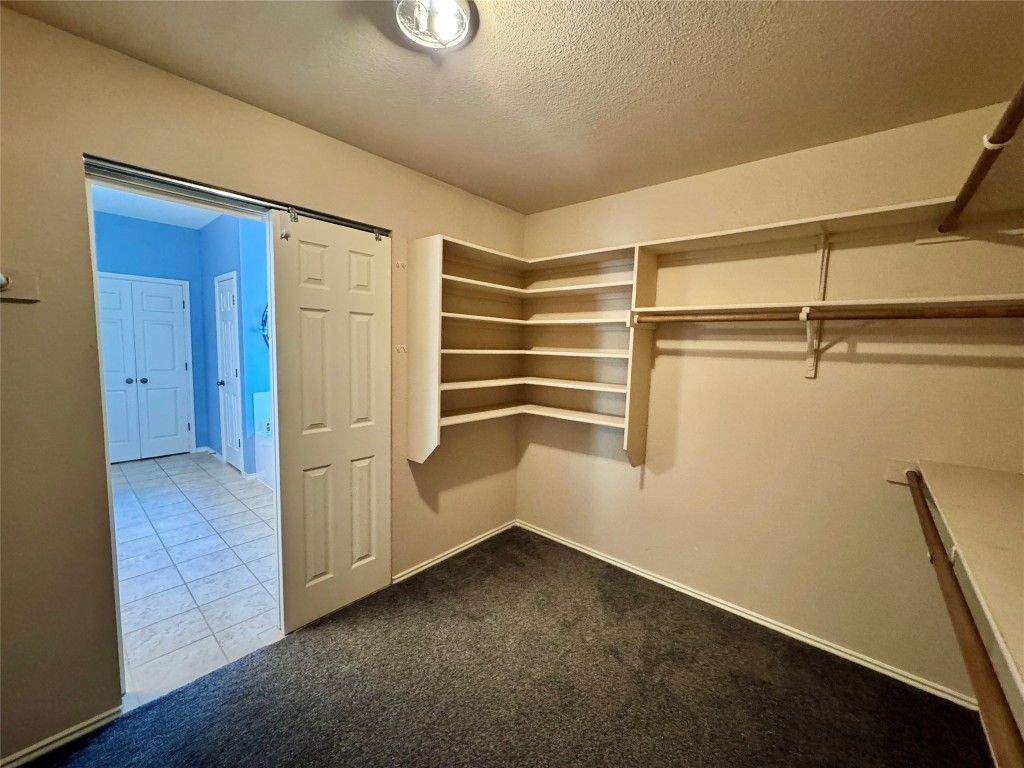 14605 Staked Plains Loop Austin, TX 78717 - Photo 15 of 30 Spacious closet with dark colored carpet and dark tile patterned flooring