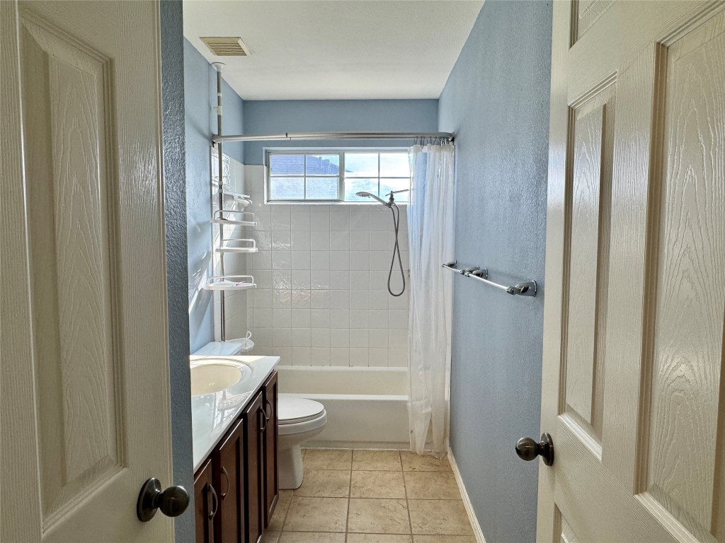 14605 Staked Plains Loop Austin, TX 78717 - Photo 19 of 30 Full bathroom with vanity, a textured wall, shower / tub combo with curtain, and light tile patterned floors