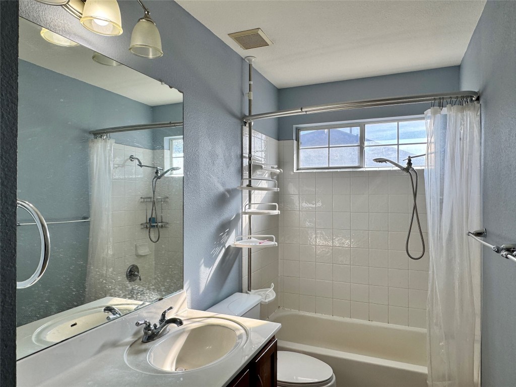 14605 Staked Plains Loop Austin, TX 78717 - Photo 20 of 30 Full bathroom featuring vanity, shower / bathtub combination with curtain, and a textured wall