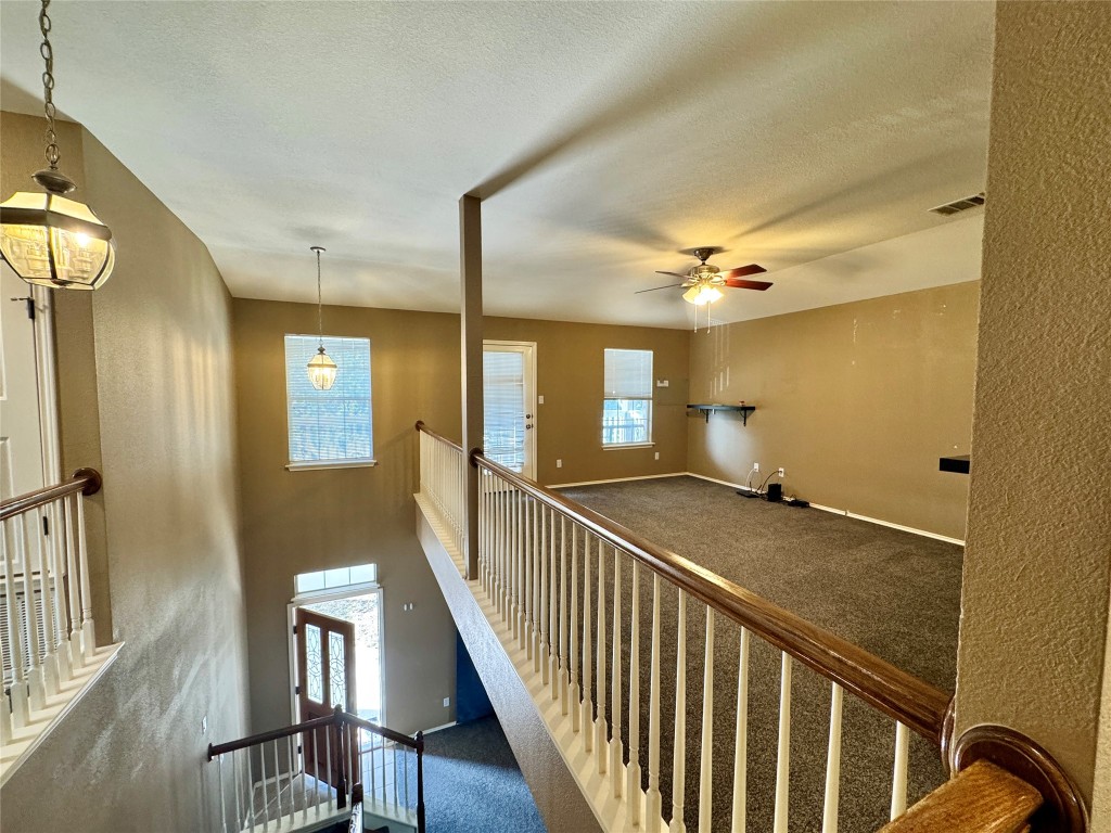 14605 Staked Plains Loop Austin, TX 78717 - Photo 7 of 30 Corridor featuring an upstairs landing, a textured ceiling, and carpet floors