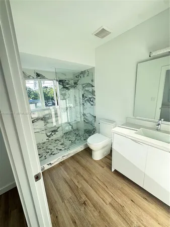 a bathroom with a sink and mirror with window
