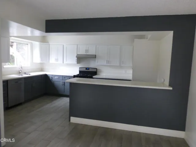 a kitchen with granite countertop white cabinets and black appliances