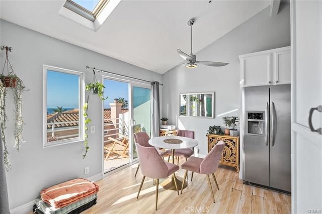 a kitchen with stainless steel appliances a dining table chairs refrigerator and microwave