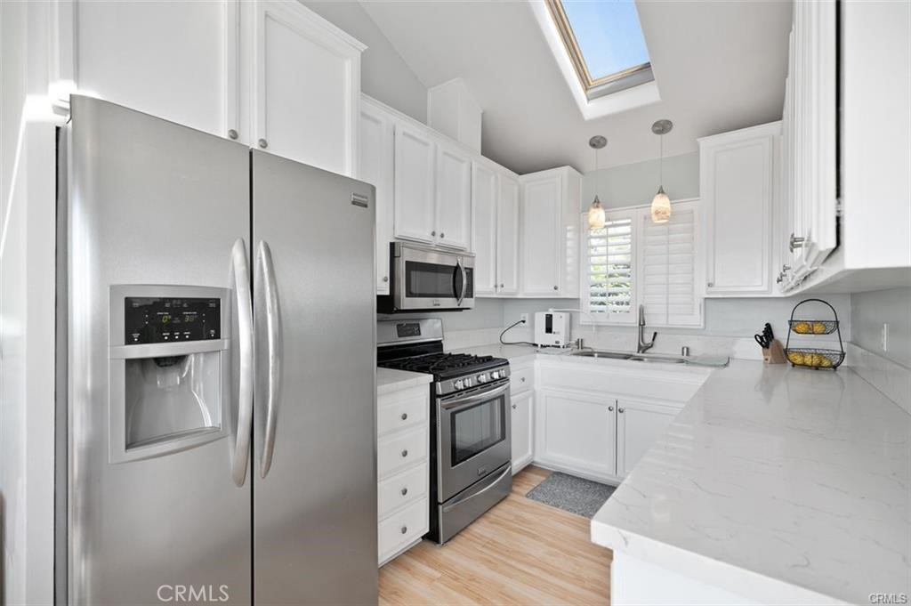 33772 Copper Lantern Street, Unit C Dana Point, CA 92629 - Photo 23 of 45 a kitchen with stainless steel appliances a refrigerator sink and microwave