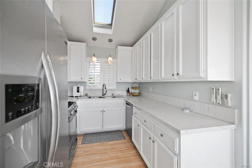 33772 Copper Lantern Street, Unit C Dana Point, CA 92629 - Photo 24 of 45 a kitchen with a sink a stove a refrigerator and cabinets