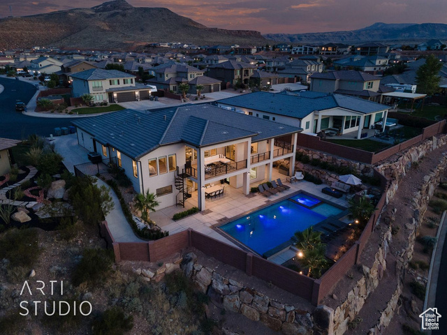 6026 Zen Trail Way St. George, UT 84790 - Photo 27 of 41 Aerial view at dusk of view of pool area, a mountain view, and a residential view