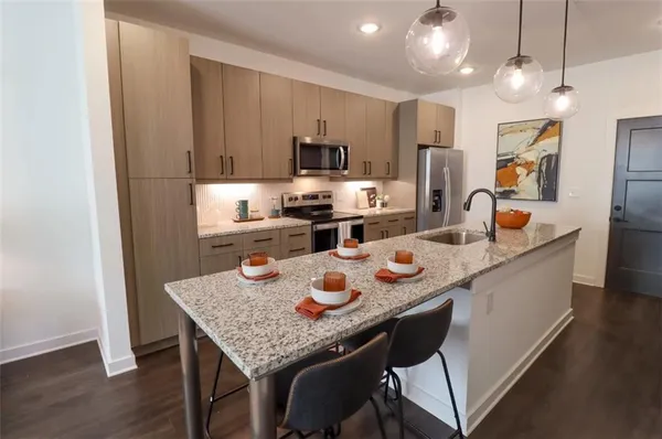 a kitchen with a dining table chairs and refrigerator