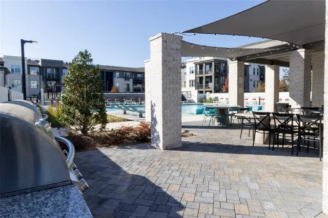 a view of a patio with table and chairs potted plants and floor to ceiling window