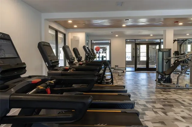 a living room with furniture a wooden floor and gym equipment
