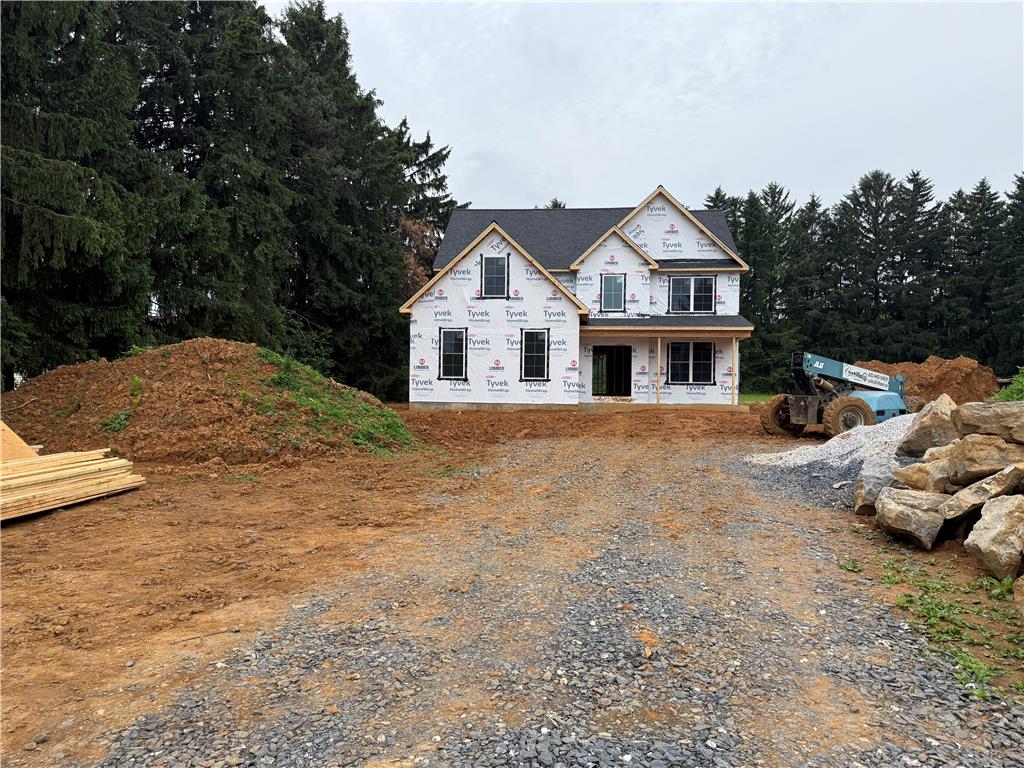 1551 Kelchner Road Bethlehem, PA 18018 - Photo 2 of 4 A newly constructed home, shrouded in weather-resistant wrap, awaits its finishing touches amidst a backdrop of mature evergreens.