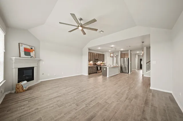 an open kitchen with white cabinets and wooden floor
