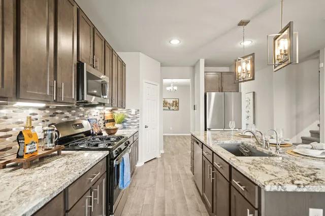 a kitchen with stainless steel appliances granite countertop a sink stove and refrigerator