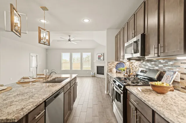 a kitchen with stainless steel appliances granite countertop a sink stove and refrigerator
