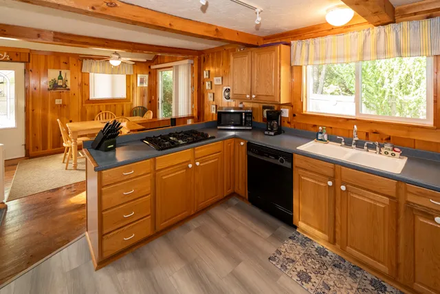 a kitchen with stainless steel appliances granite countertop a sink counter space and a large window