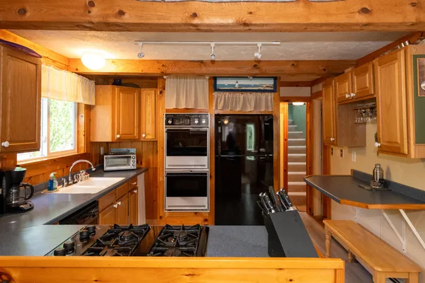 a kitchen with stainless steel appliances granite countertop a sink a stove and a refrigerator