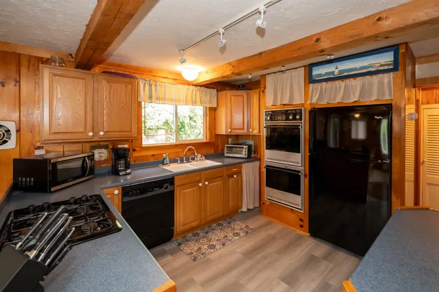 a kitchen with stainless steel appliances granite countertop a refrigerator a stove a sink and a microwave