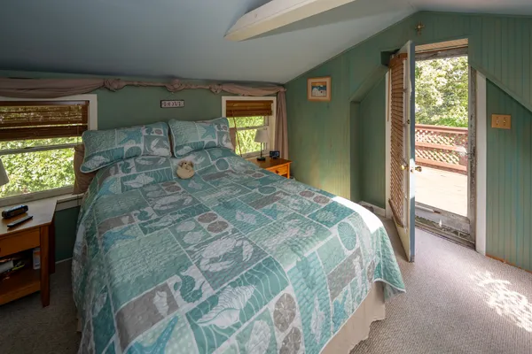 a bed sitting in a bedroom next to a window