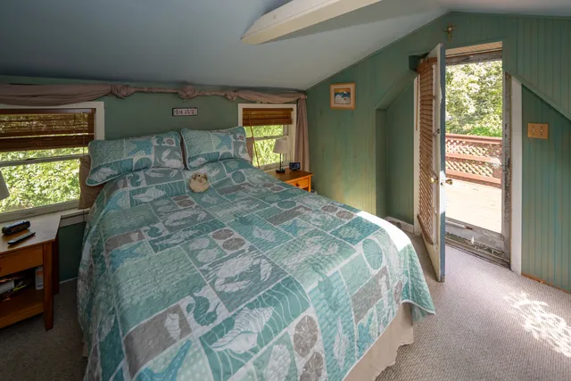 a bed sitting in a bedroom next to a window