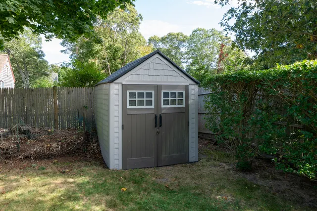 a view of a house with a small yard plants and large tree