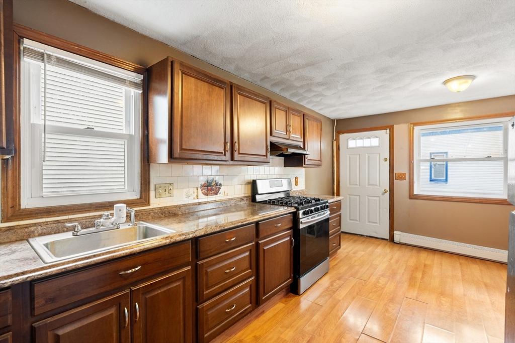 23 Logan Street Lynn, MA 01902 - Photo 6 of 27 a kitchen with stainless steel appliances granite countertop a sink stove and refrigerator