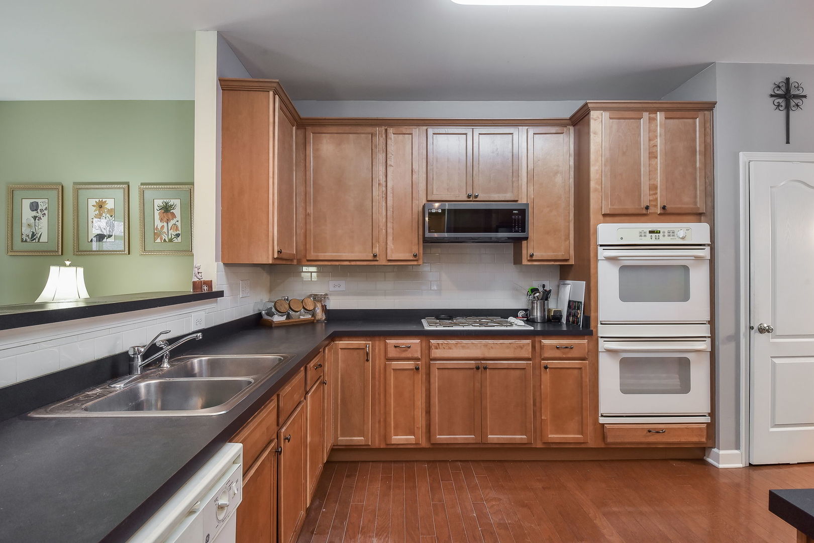708 Bohannon Circle Oswego, IL 60543 - Photo 6 of 24 a kitchen with stainless steel appliances granite countertop a sink a stove cabinets and wooden floor