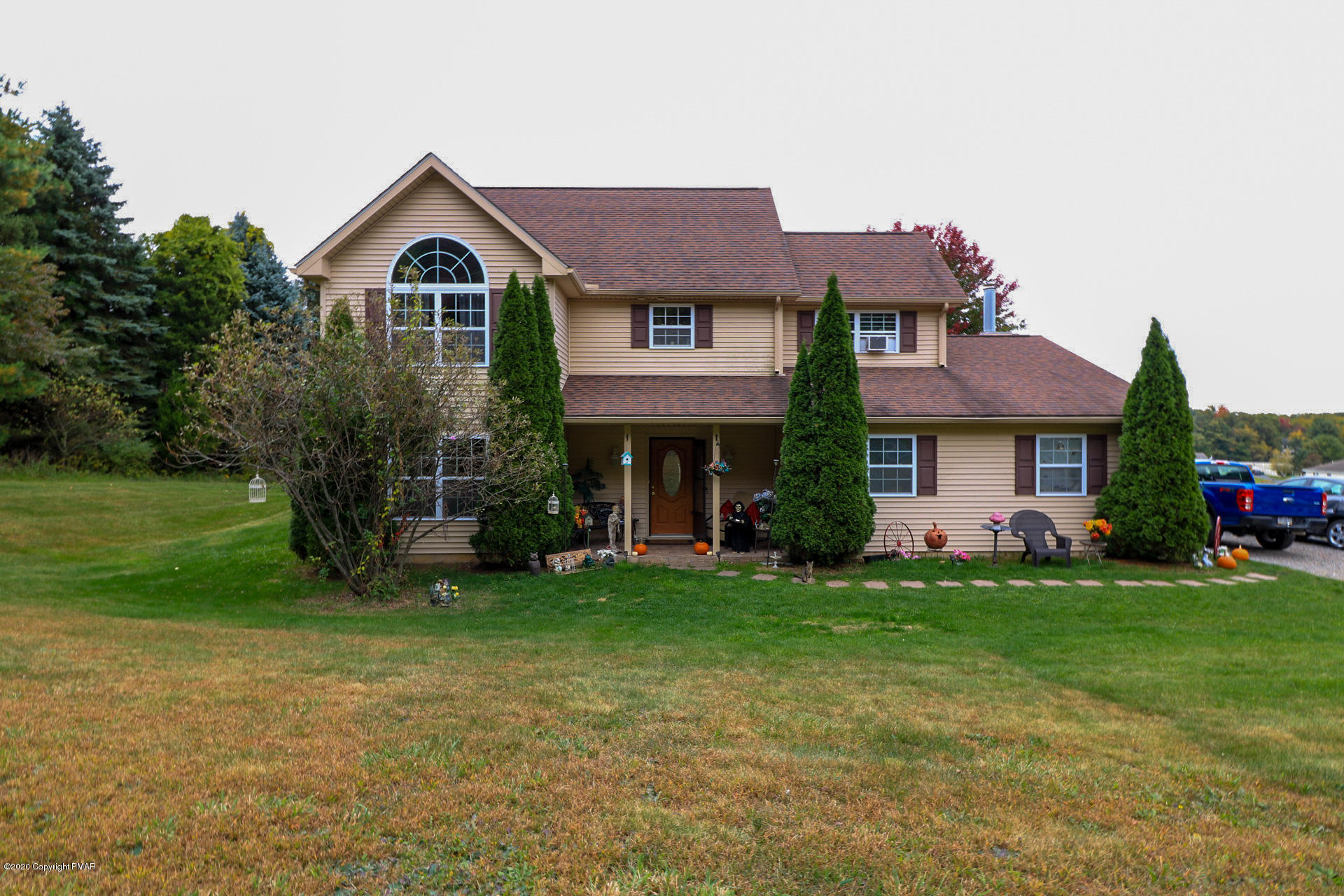 a front view of a house with a garden and yard