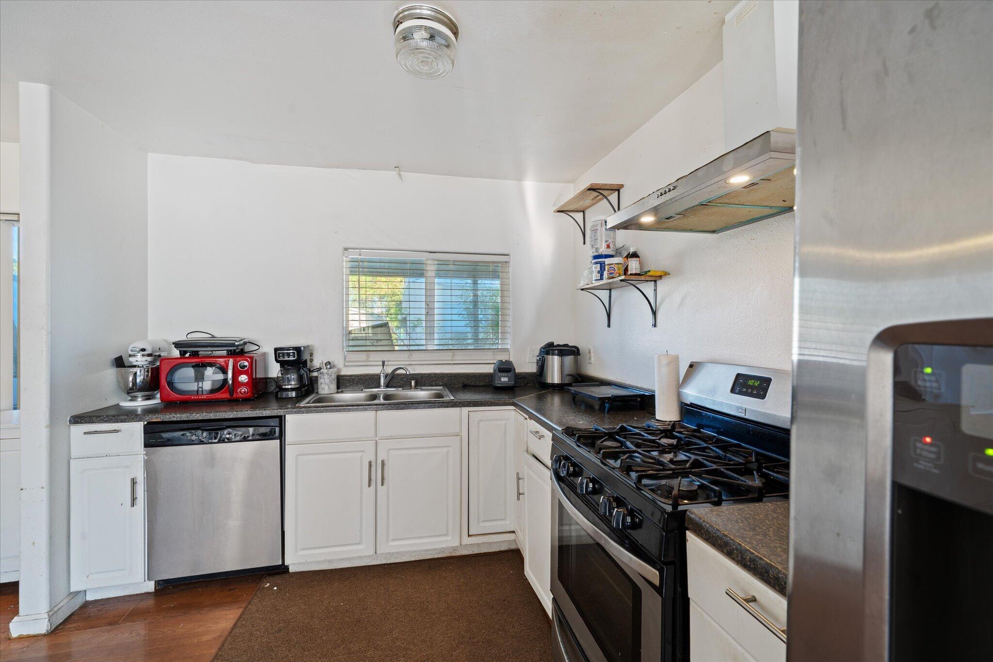 2494 Delta Place, Unit 71 Redding, CA 96002 - Photo 8 of 24 a kitchen with stainless steel appliances a white sink stove and refrigerator