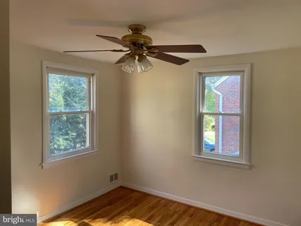 a view of empty room with window and wooden floor