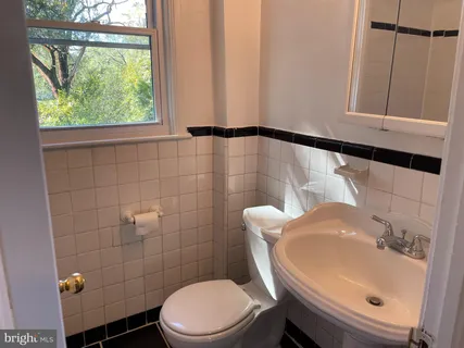 a bathroom with a sink a toilet and a mirror