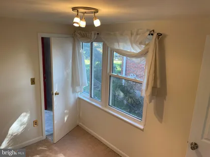 a view of a hallway with a window and chandelier