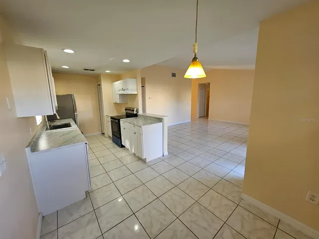 a kitchen with stainless steel appliances granite countertop a sink a stove top oven and cabinets