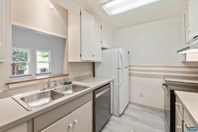 a kitchen with appliances a sink and cabinets