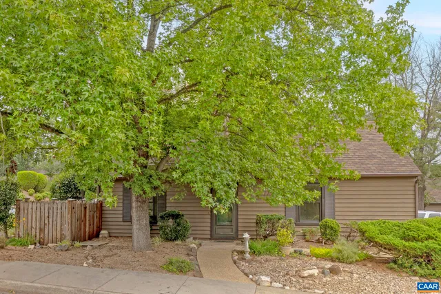 a front view of a house with a tree