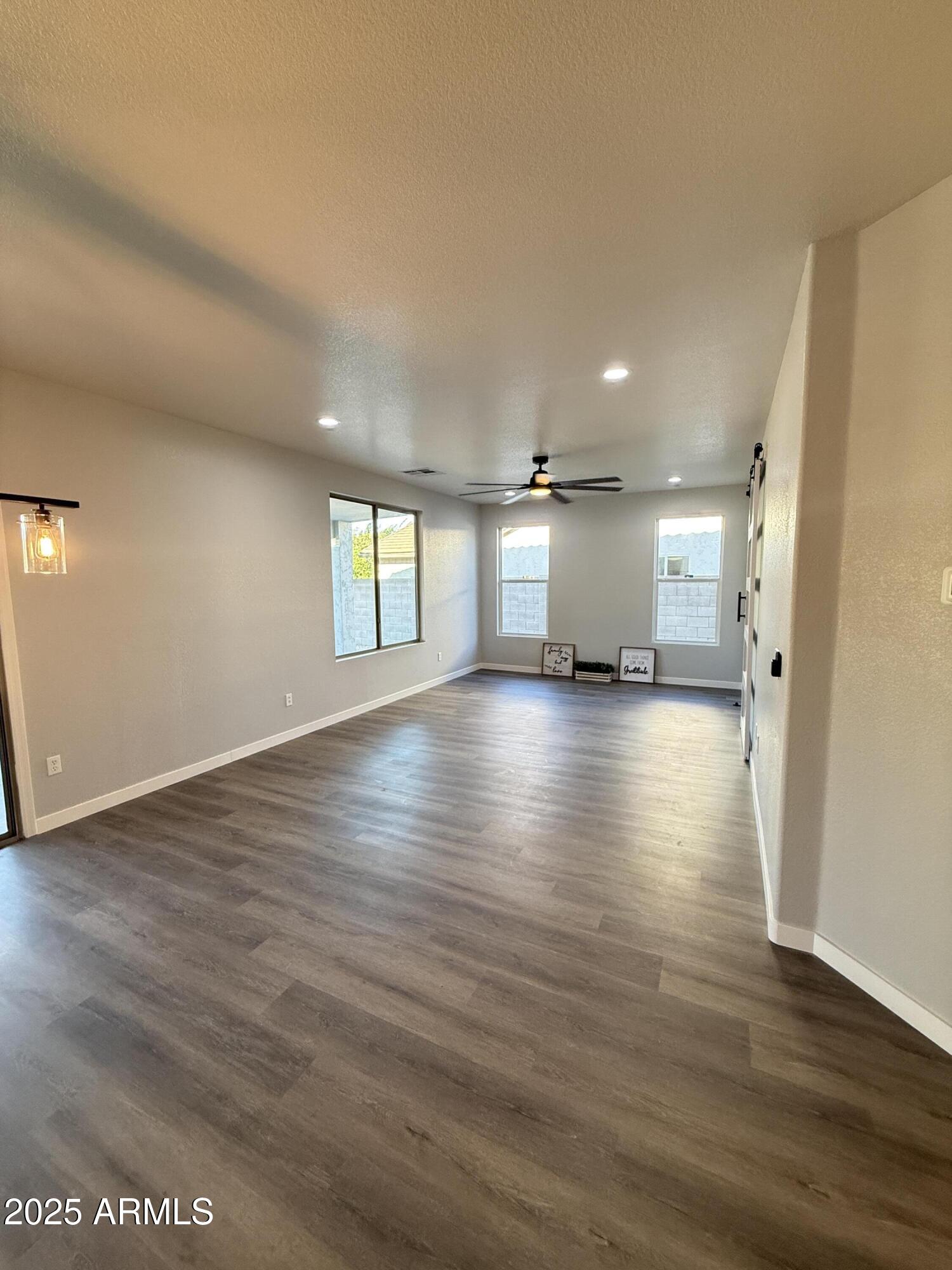 2972 West South Butte Road Queen Creek, AZ 85144 - Photo 5 of 17 an empty room with wooden floor and windows