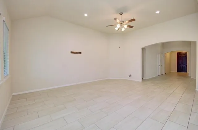 wooden floor in an empty room and a chandelier fan