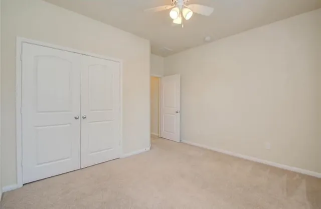 an empty room with a chandelier fan