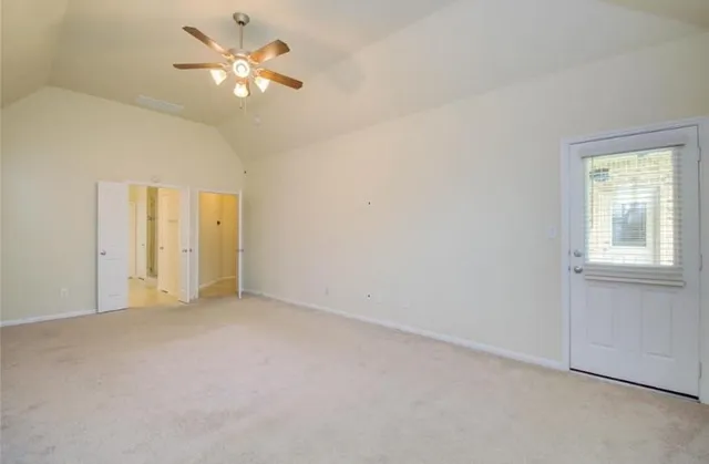 an empty room with a window and a ceiling fan