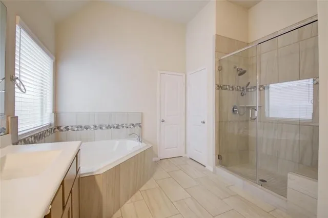a bathroom with a tub sink and shower