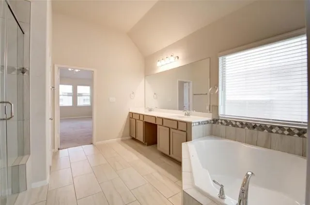 a large spacious bathroom with a tub sink and mirror