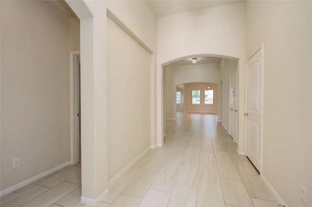 a view of a hallway with wooden floor and a living room