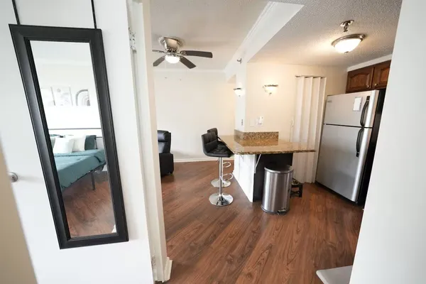 a view of a hallway with wooden floor and furniture