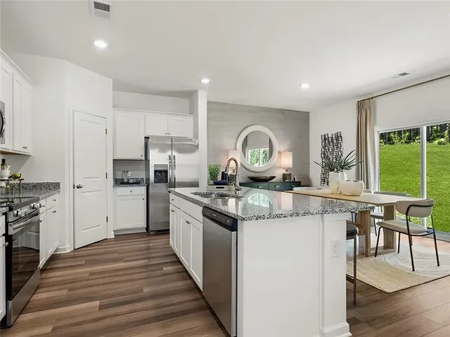 a kitchen with stainless steel appliances granite countertop a stove and a refrigerator