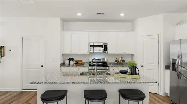 a kitchen with stainless steel appliances granite countertop a sink and a refrigerator