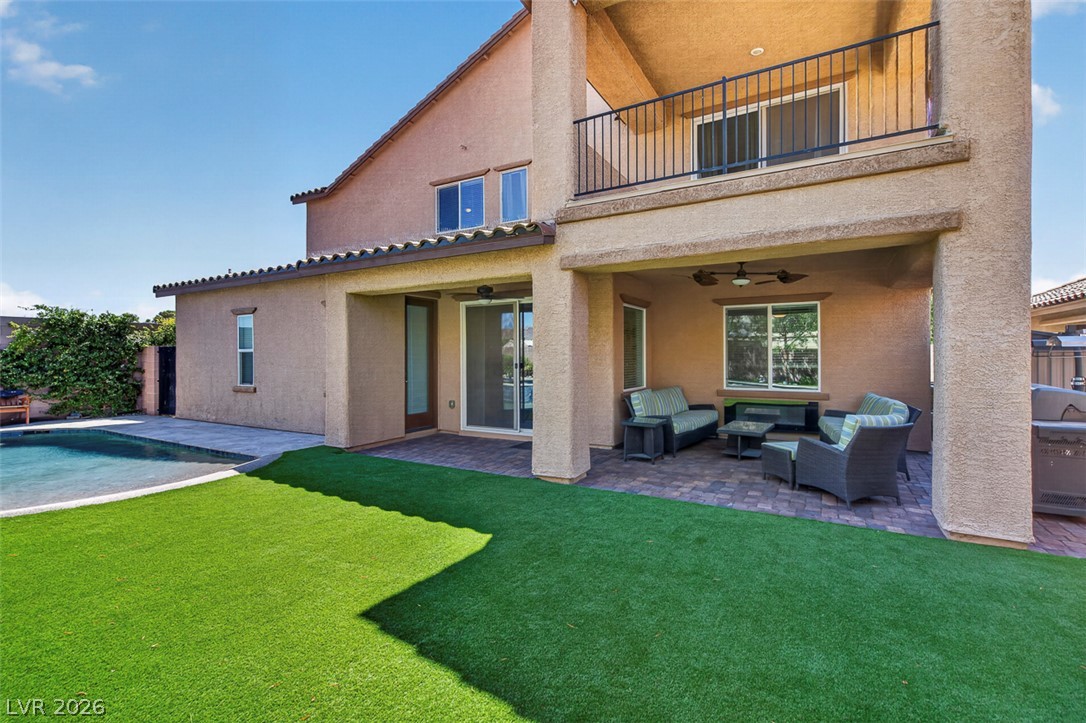 1824 Redland Ridge Street Henderson, NV 89002 - Photo 66 of 69 An inviting outdoor living space features a covered patio, private pool, and lush green yard.