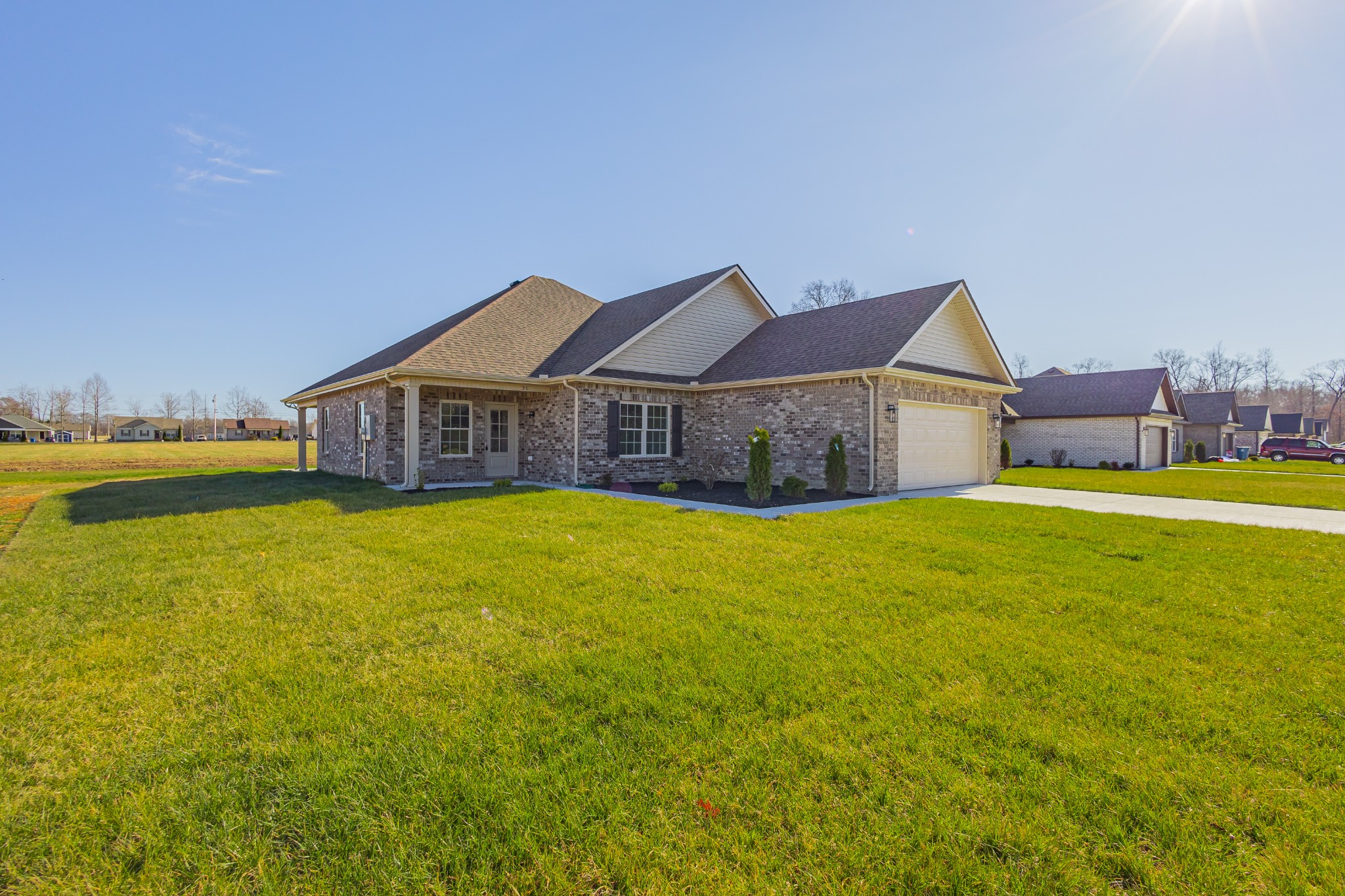 a front view of a house with yard and lake view