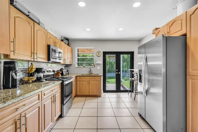 a kitchen with granite countertop a refrigerator and a sink