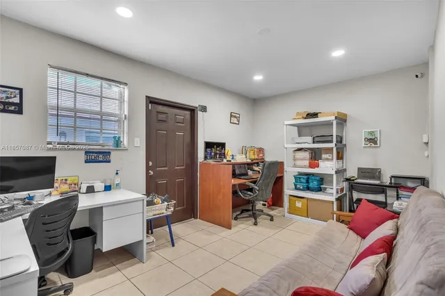 a view of a workspace with furniture and a window