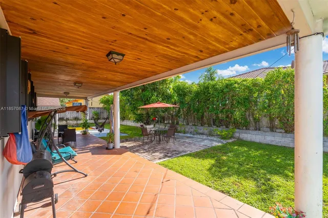 a view of a patio with a table chairs and a backyard