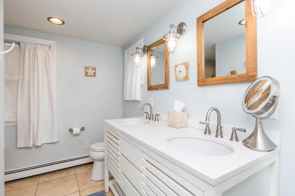 a bathroom with a sink a toilet and a mirror