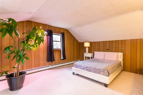 a spacious bedroom with a bed and a potted plant
